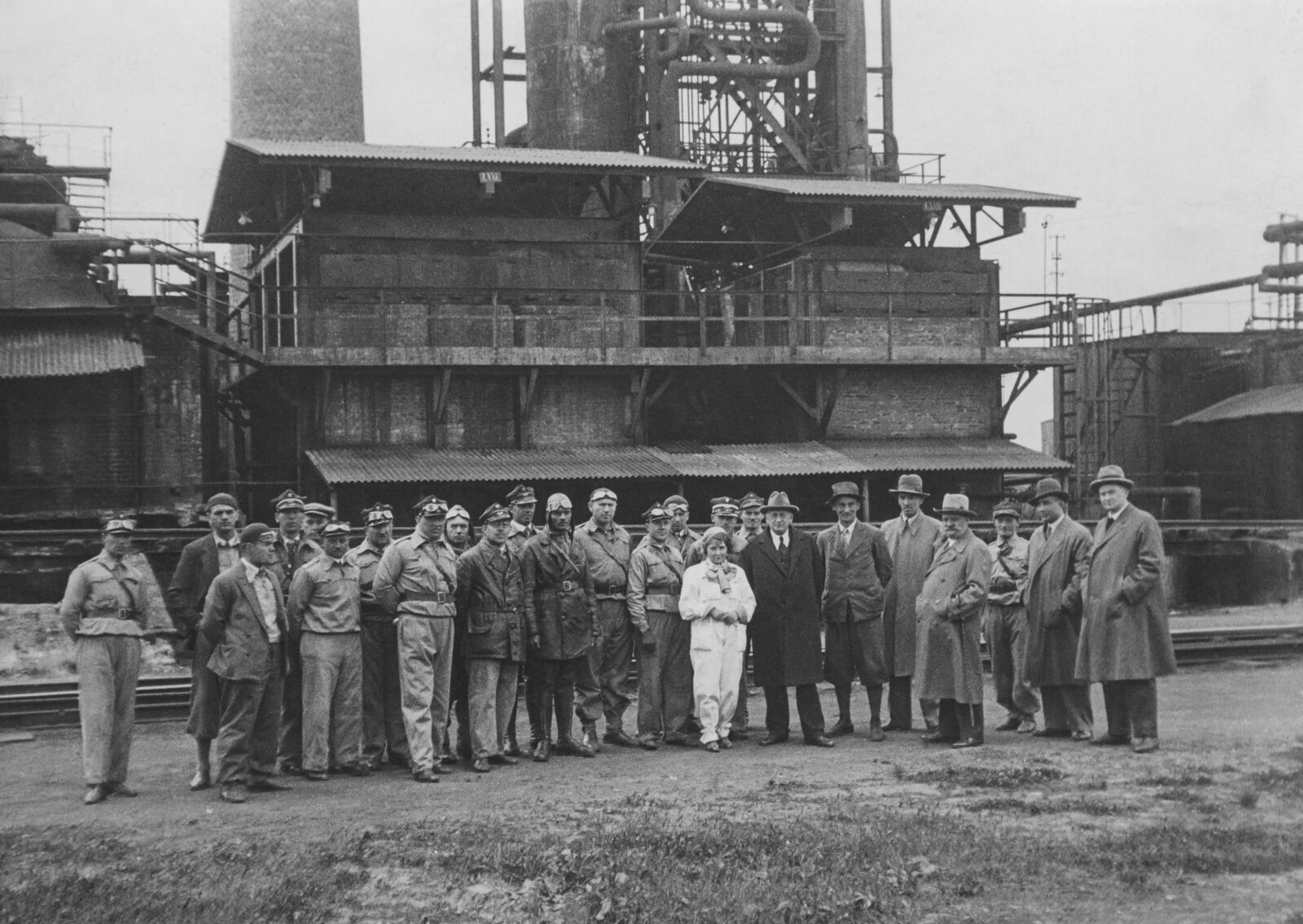 Fotografia uczestników rajdu motocyklowego z przedstawicielami firmy Vacuum Oil Company na terenie rafinerii. Widoczni m.in. dyrektor Aleksander Kopczyński i inżynier Kołodziejczyk, lata 30. XX wieku